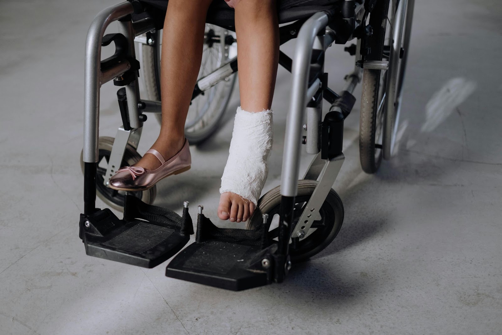 A young girl with an injured leg on a wheel chair