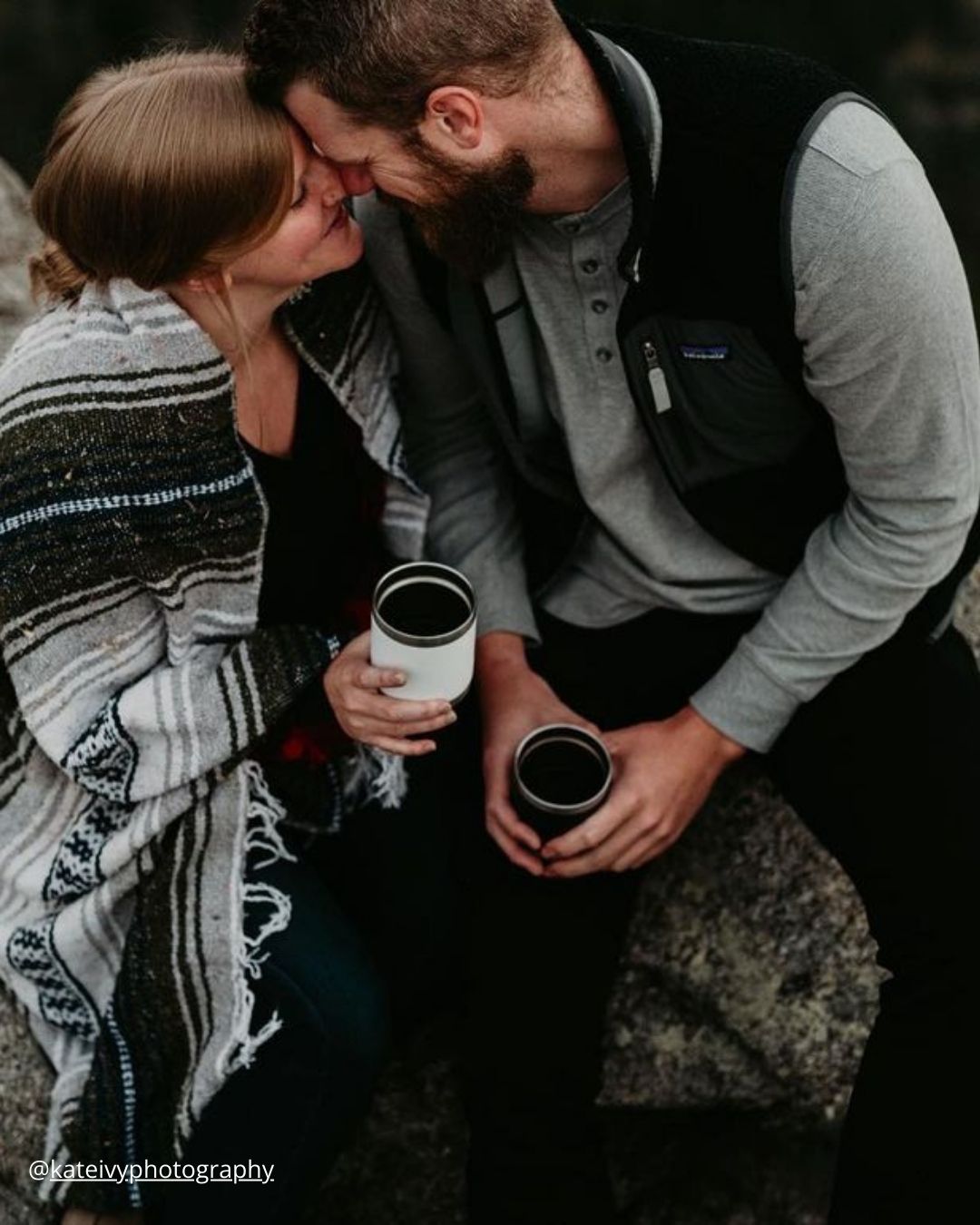 winter engagement photos couple with blankets is drinking hot tea in mugs