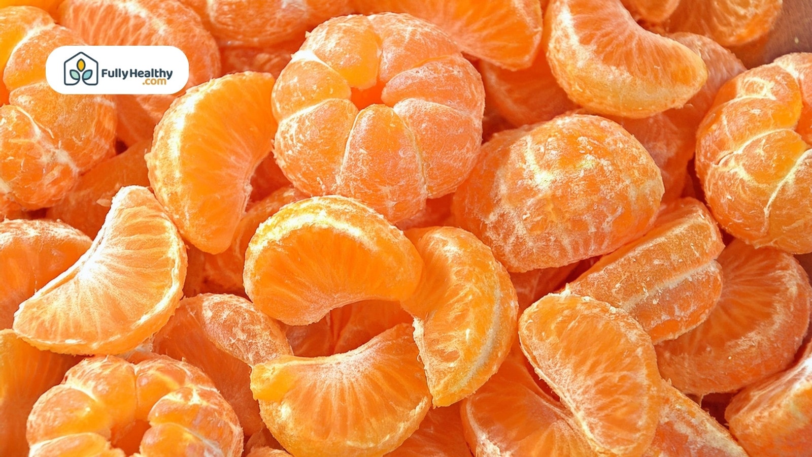 Peeled mandarin orange segments piled closely with bright vibrant color