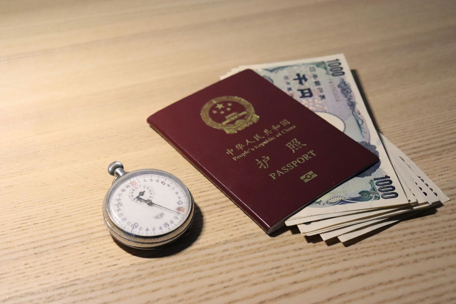 A passport with some money inside and a stopwatch