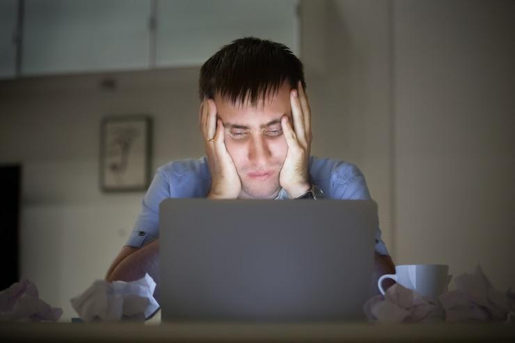 Portrait of a man at the desk near laptop, late night