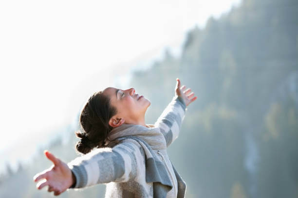 A cheerful woman outdoors in winter, surrounded by snow, radiating mental wellness and joy.