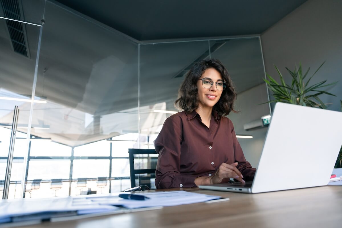 Leave of absence compliance: employee wearing a pair of eyeglasses while using a laptop