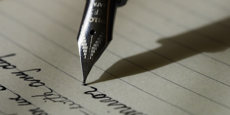 Person writing in notebook with laptop nearby