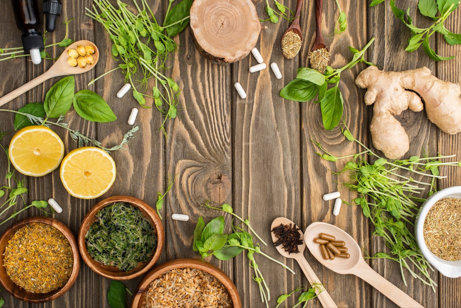 Pill capsules, vegetables, and herbs on a wooden surface. 