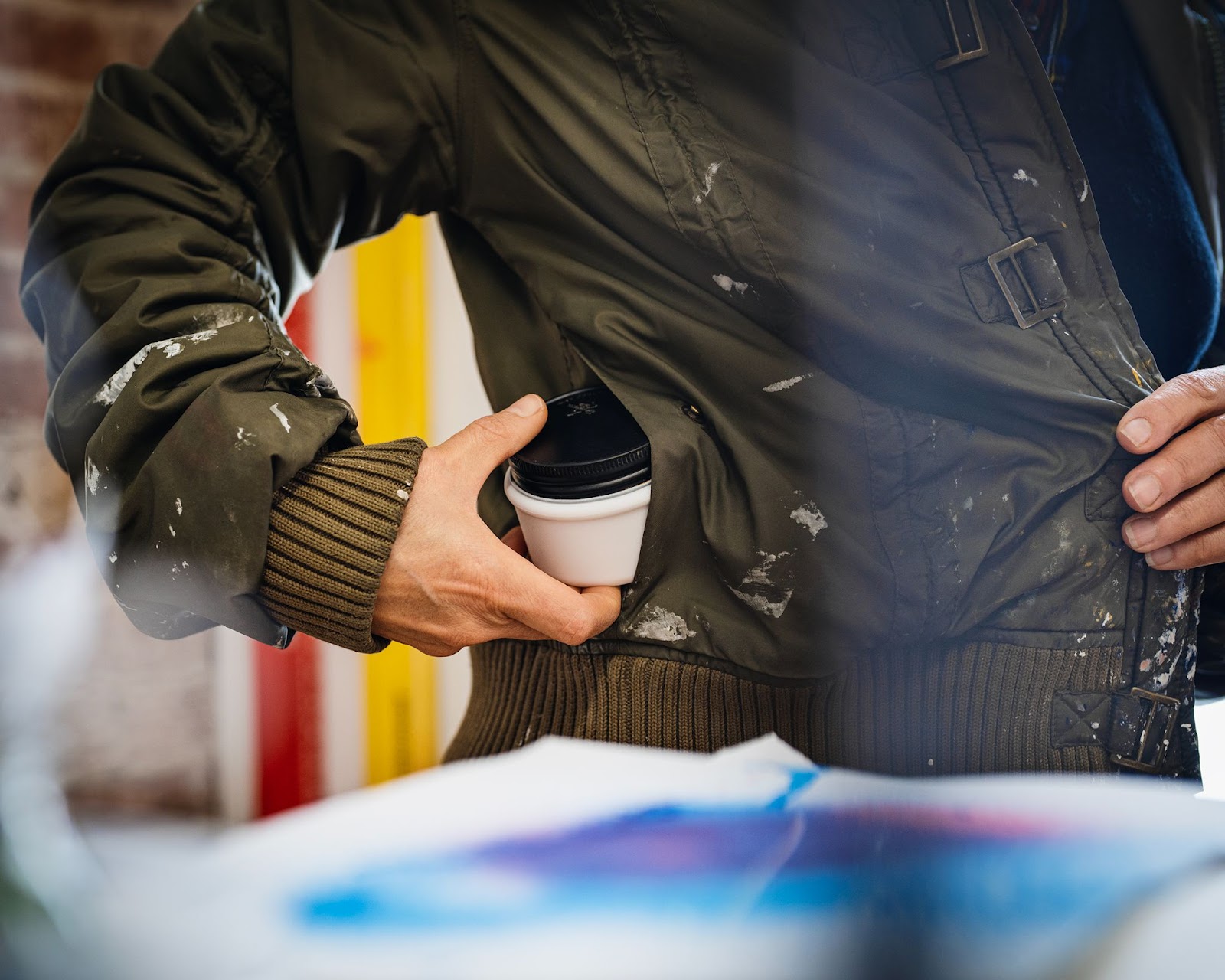 Person putting a white ESS Mini in jacket pocket