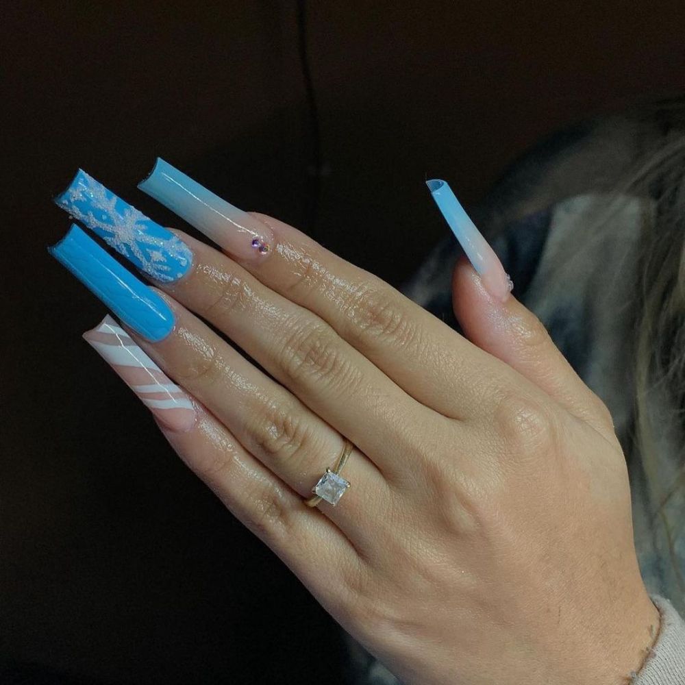 Close up of hands with blue winter nails having beautiful Winter Manicure