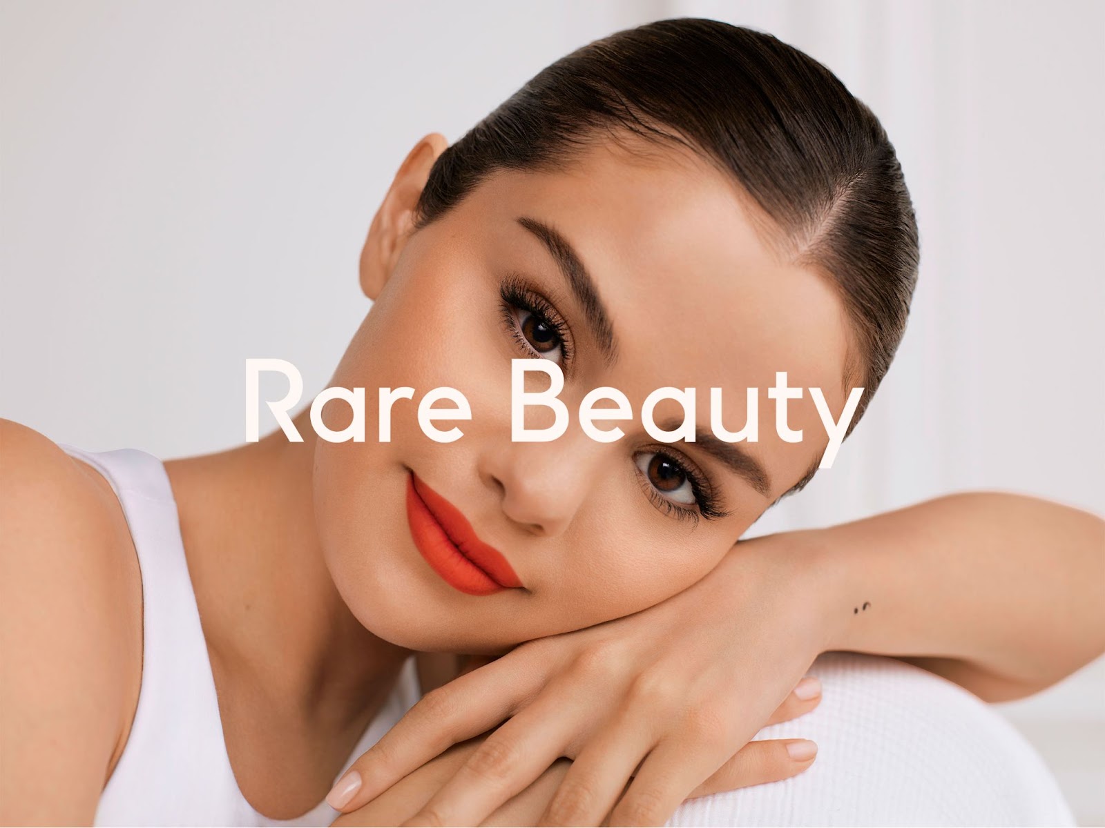 Image of Selena Gomez with the Rare Beauty logo.