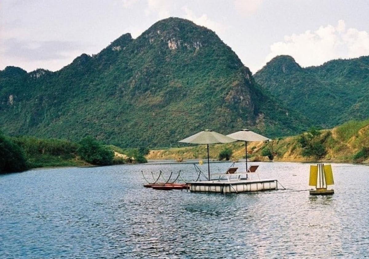 A floating dock with umbrellas and a yellow tent on the water

Description automatically generated