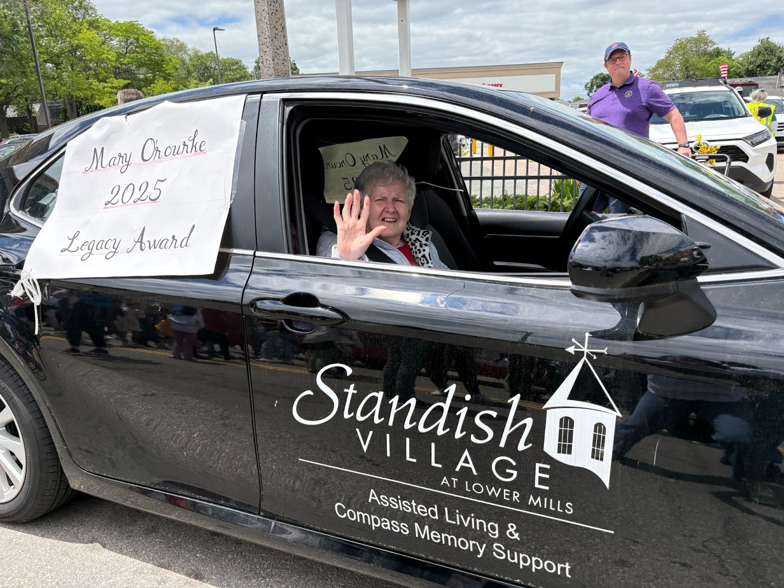 Woman in car, waving
