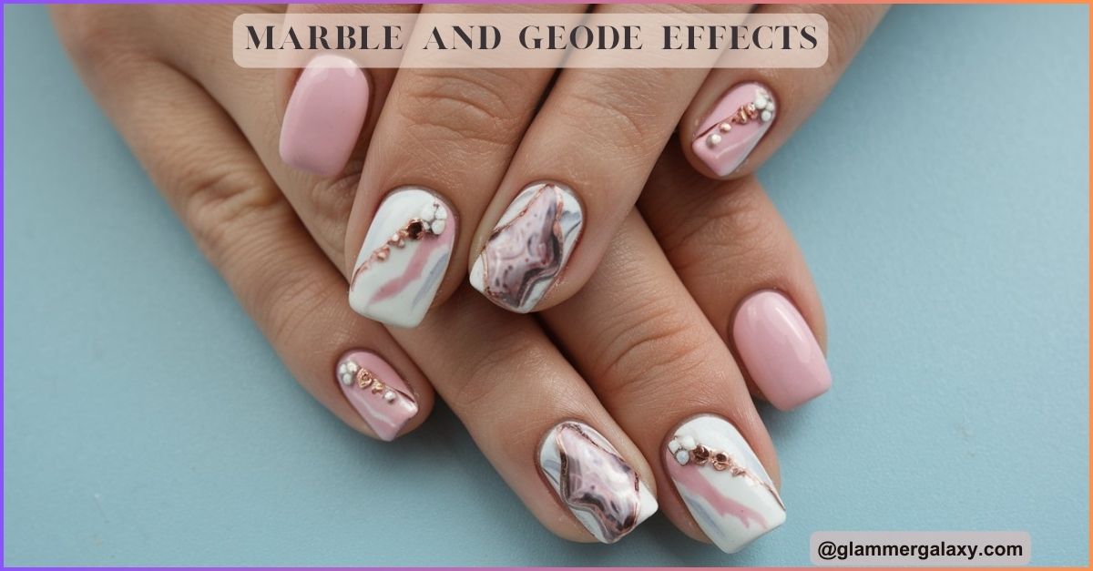 Manicured nails with pink polish and marble geode design on a blue background.