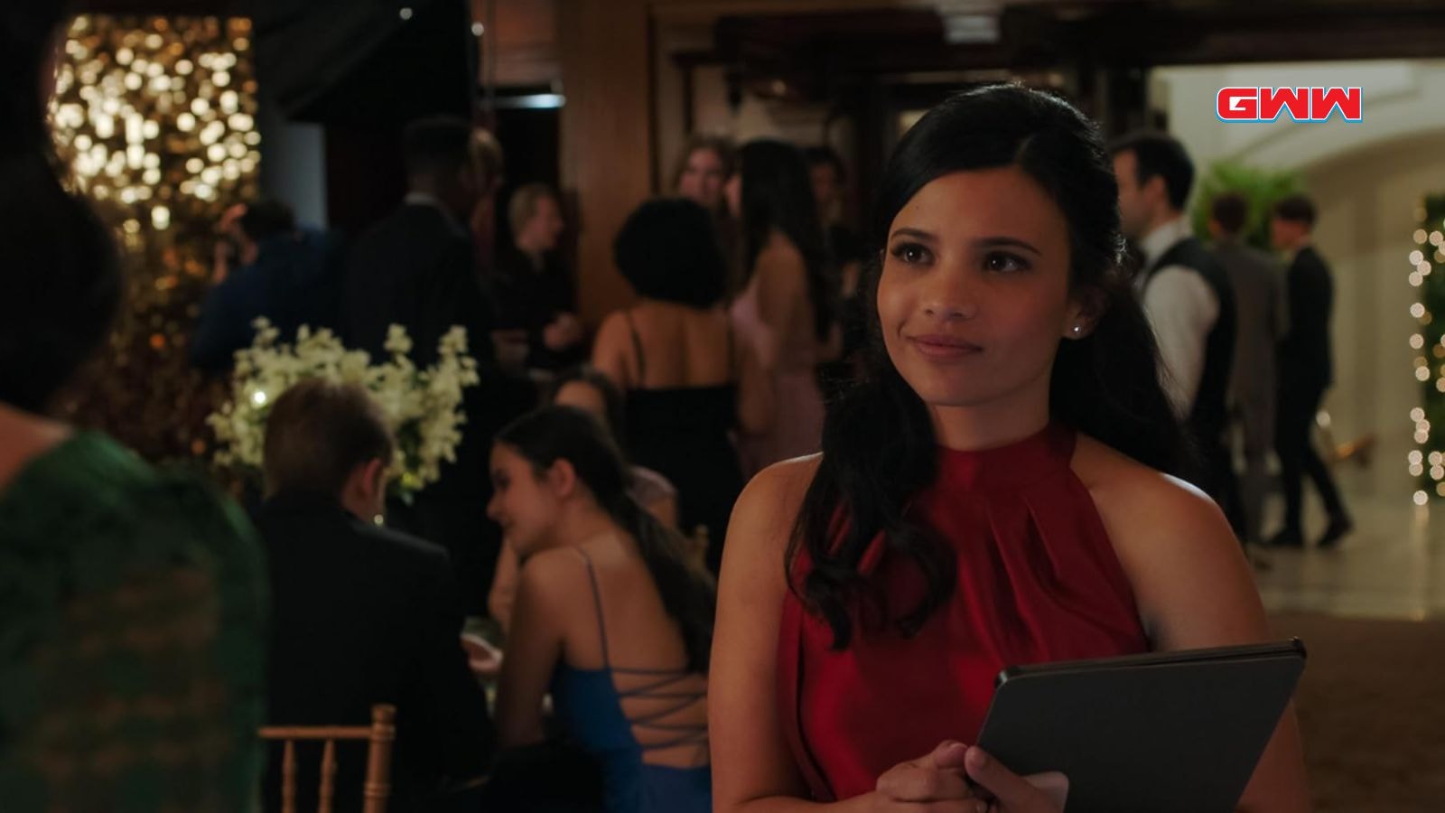 Jackie Howard dressed elegantly, holding a tablet at a formal event.