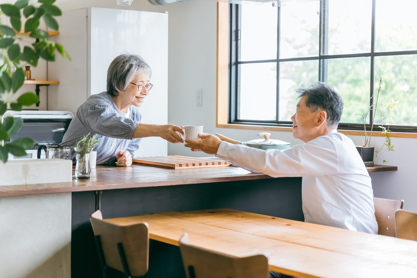 家のキッチンでコーヒーをいれる老夫婦