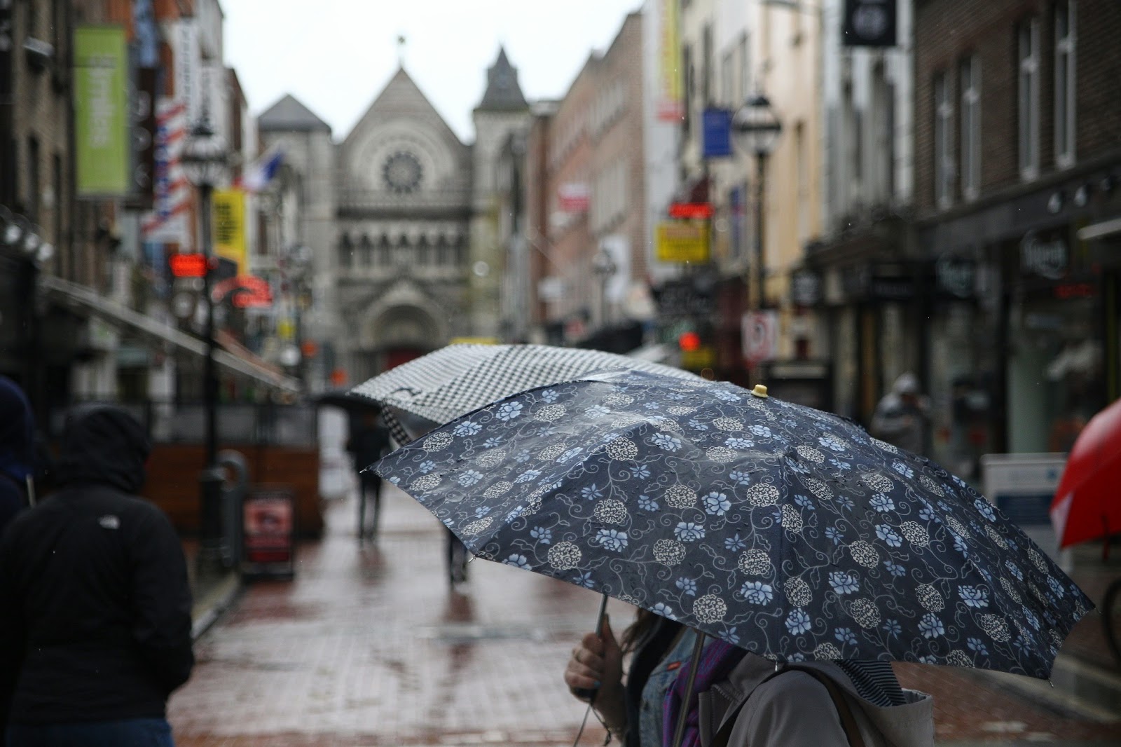 A traveler holding an umbrella, ready to explore Ireland’s historic sites.