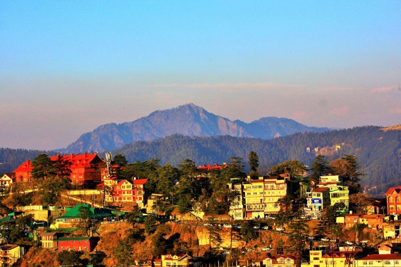A breathtaking view of Shimla, Himachal Pradesh, featuring colonial-style architecture, pine-covered hills, and a vibrant Mall Road.
