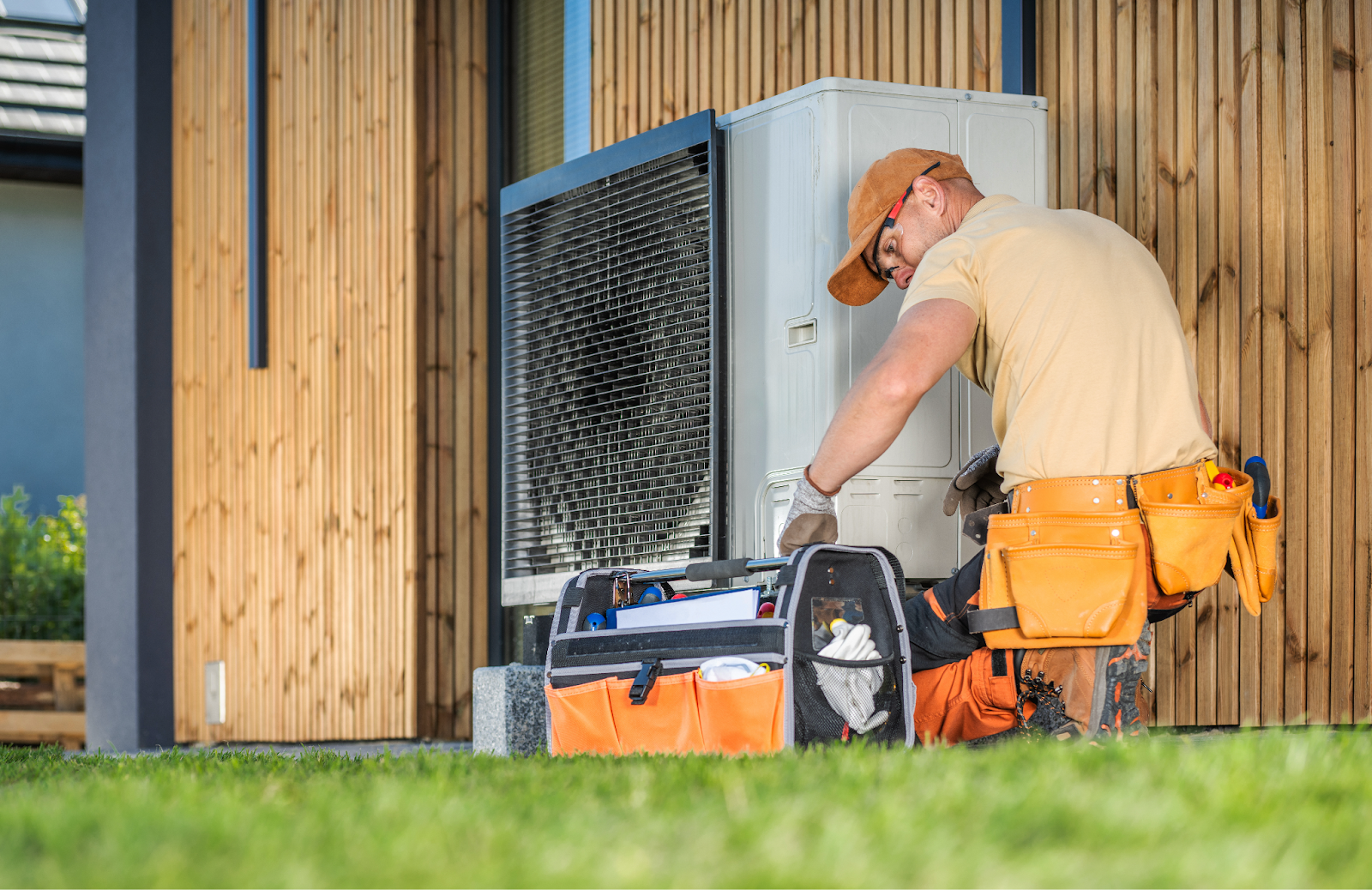 A contractor repairing a heat pump unit