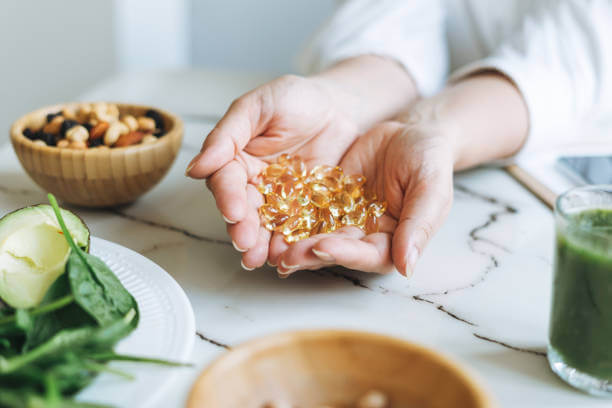 A woman showcasing flaxseed oil capsules in her palms, highlighting a plant-based source of omega-3.