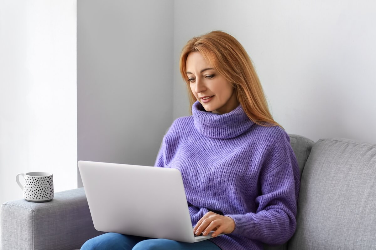 Leave of absence Florida: employee sitting on a couch while using a laptop