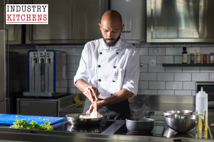 A chef in uniform skillfully prepares food using an induction cooktop in a modern kitchen setting.
