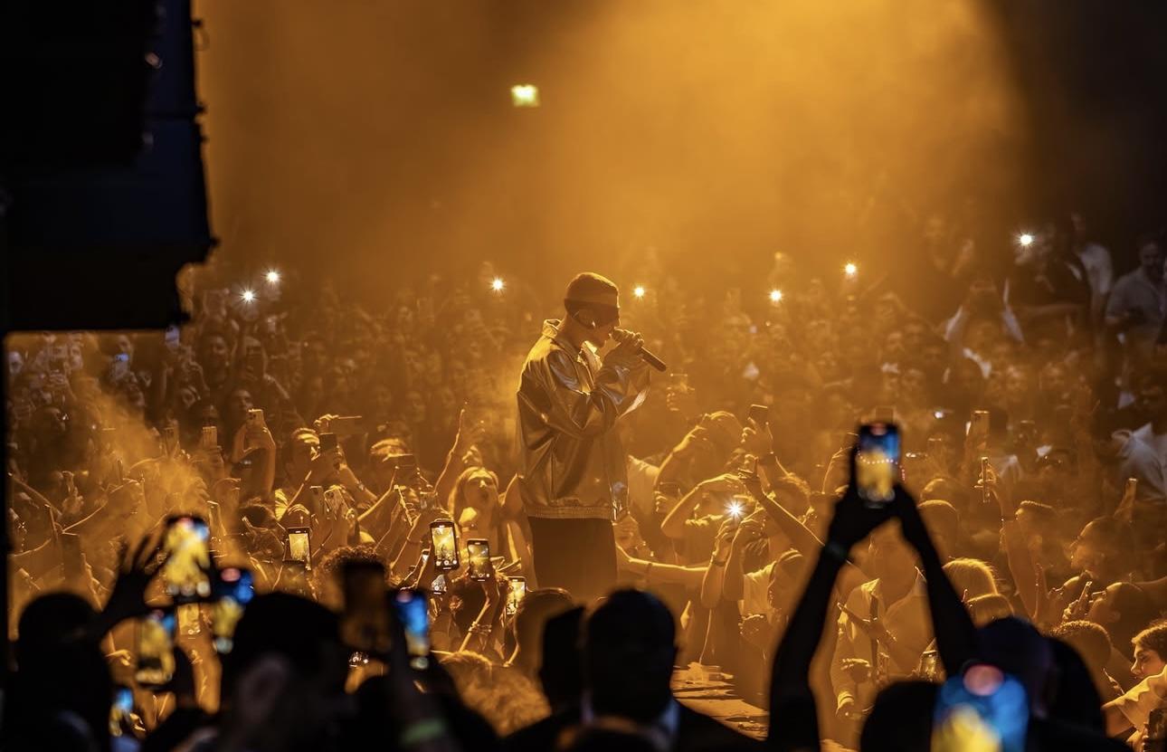 A person on stage with microphone in front of crowd of people

AI-generated content may be incorrect.