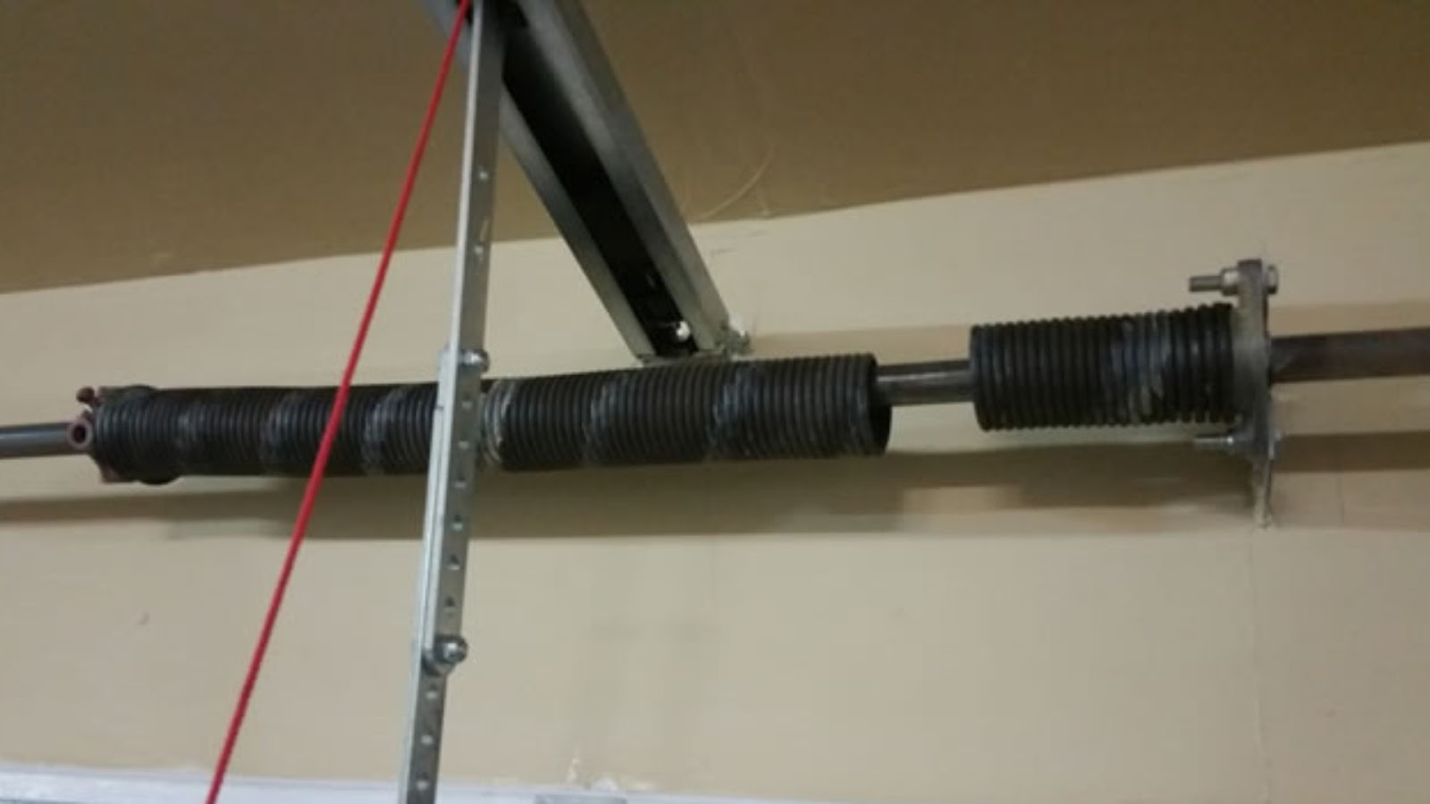 A broken garage door spring that needs replacement