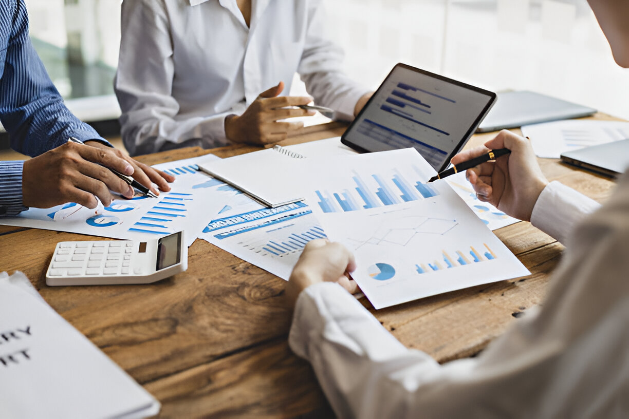 Business team reviewing financial reports and charts, illustrating how bookkeeping can improve financial management and decision-making.