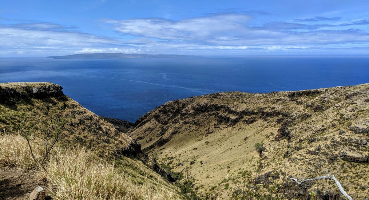 Aerial view of rocky Lahaina Pali Trail with sweeping ocean views and Kahoʻolawe Island visible in the distance