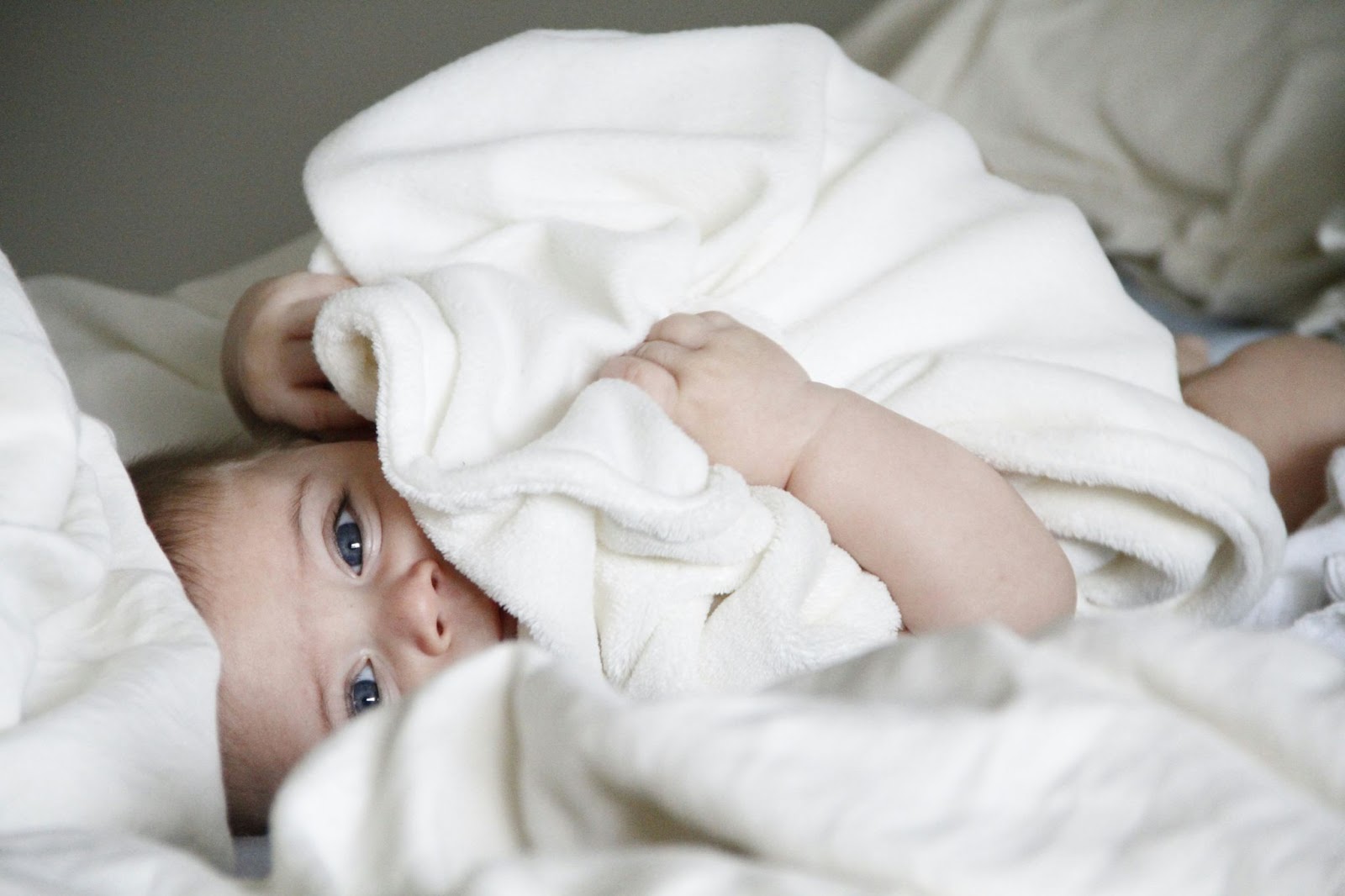 A baby in white sheets.