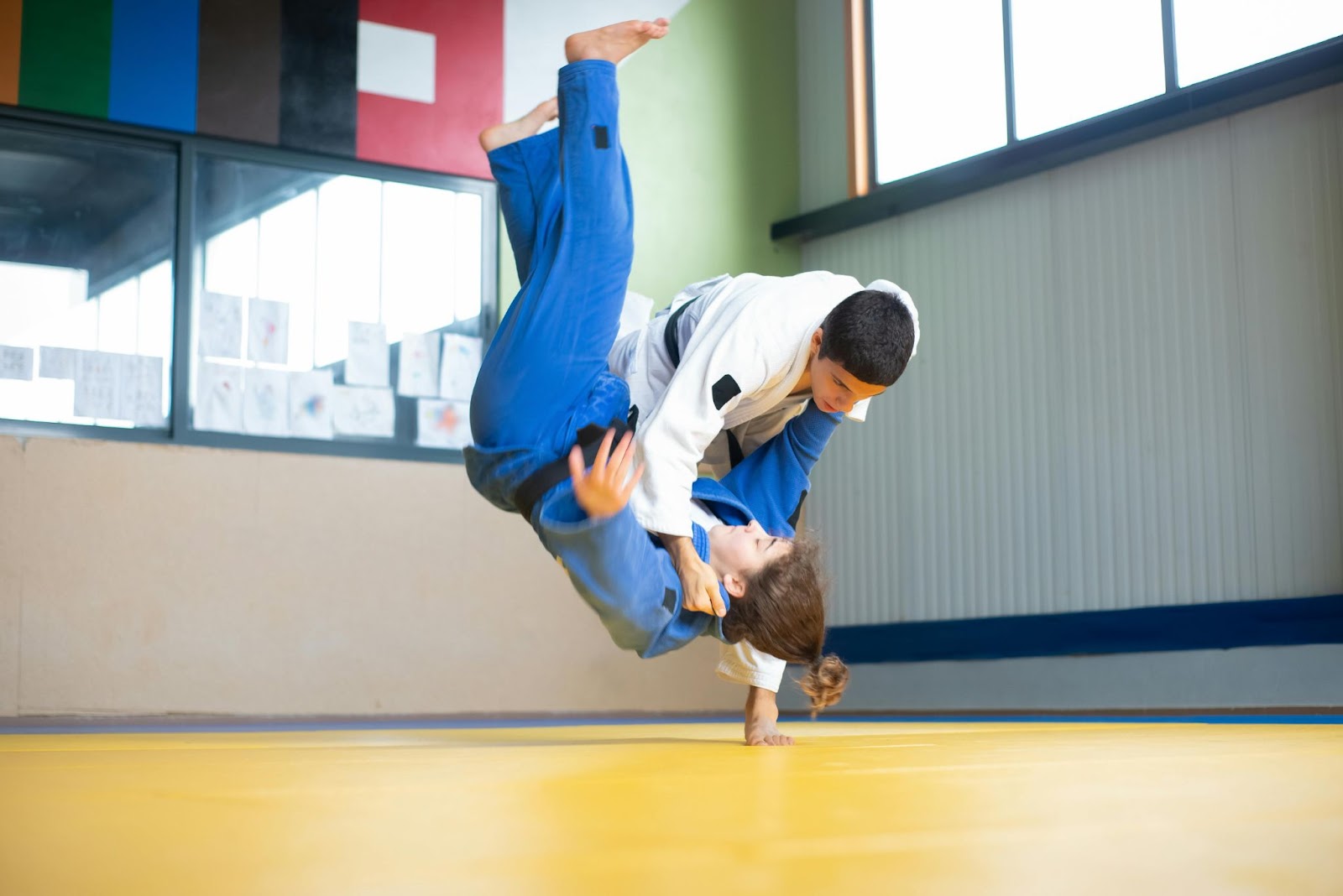 A martial arts student performs a succesful takedown after a leg sweep on an oponent