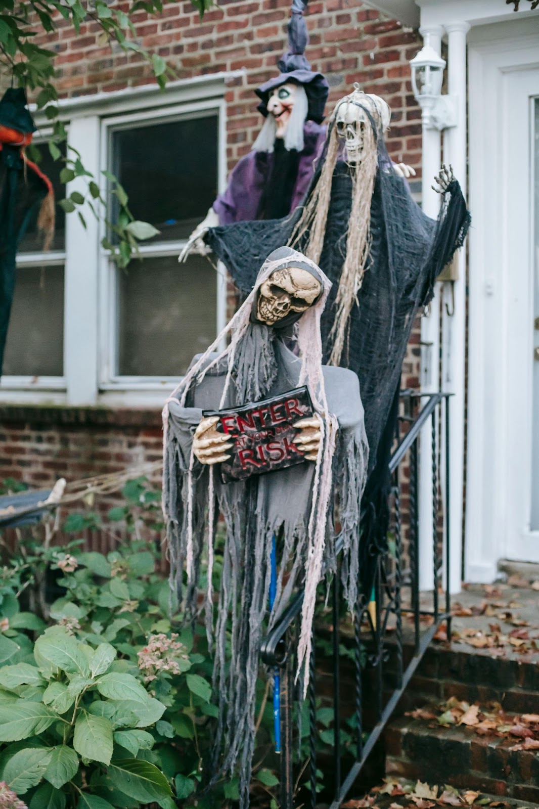 Front of a house with three halloween figurine decorations