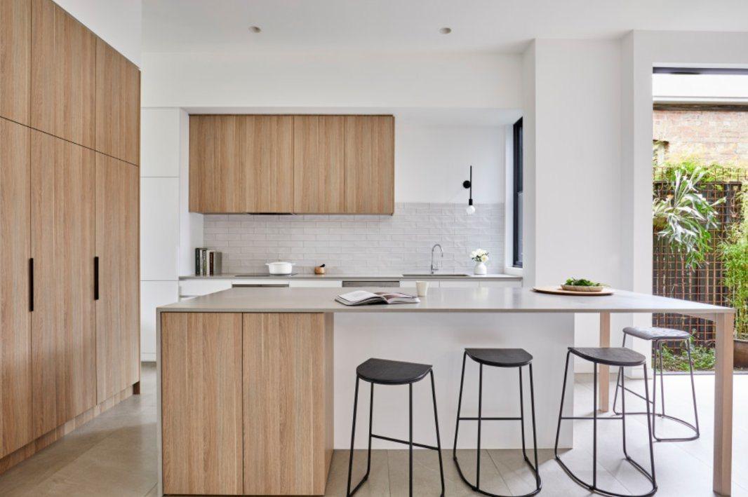 A kitchen with a bar stools

Description automatically generated