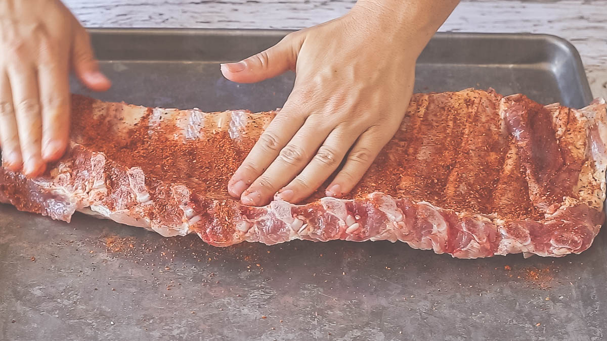 Firmly rub in to coat pork ribs with seasonings