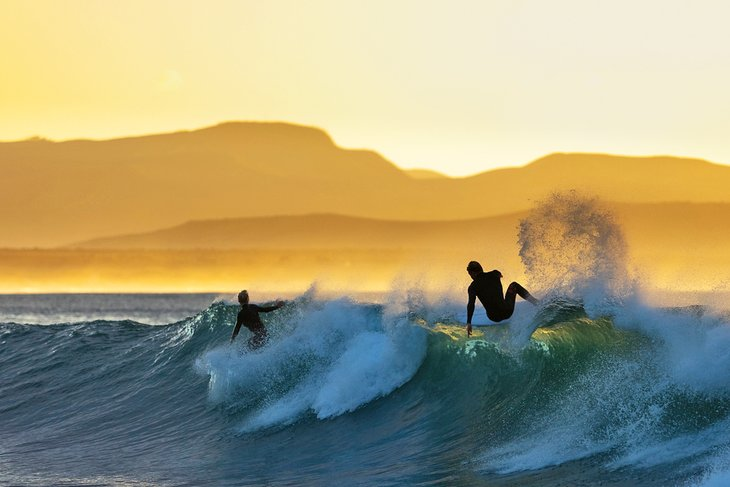 Surfers in Supertubes at sunrise - Jeffrey's Bay, South Africa