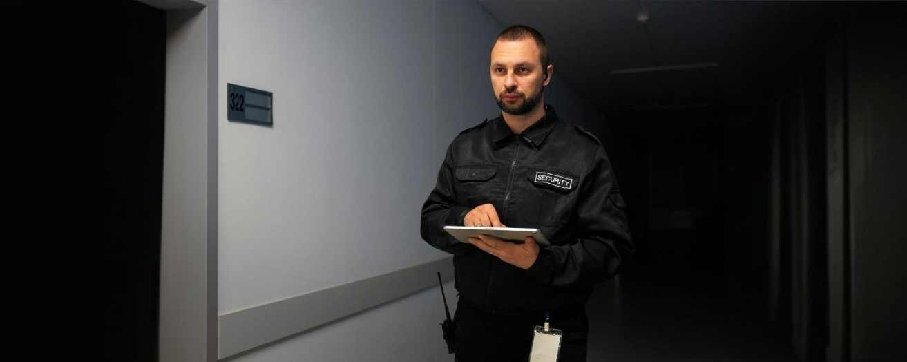 A security guard on duty, wearing a black uniform