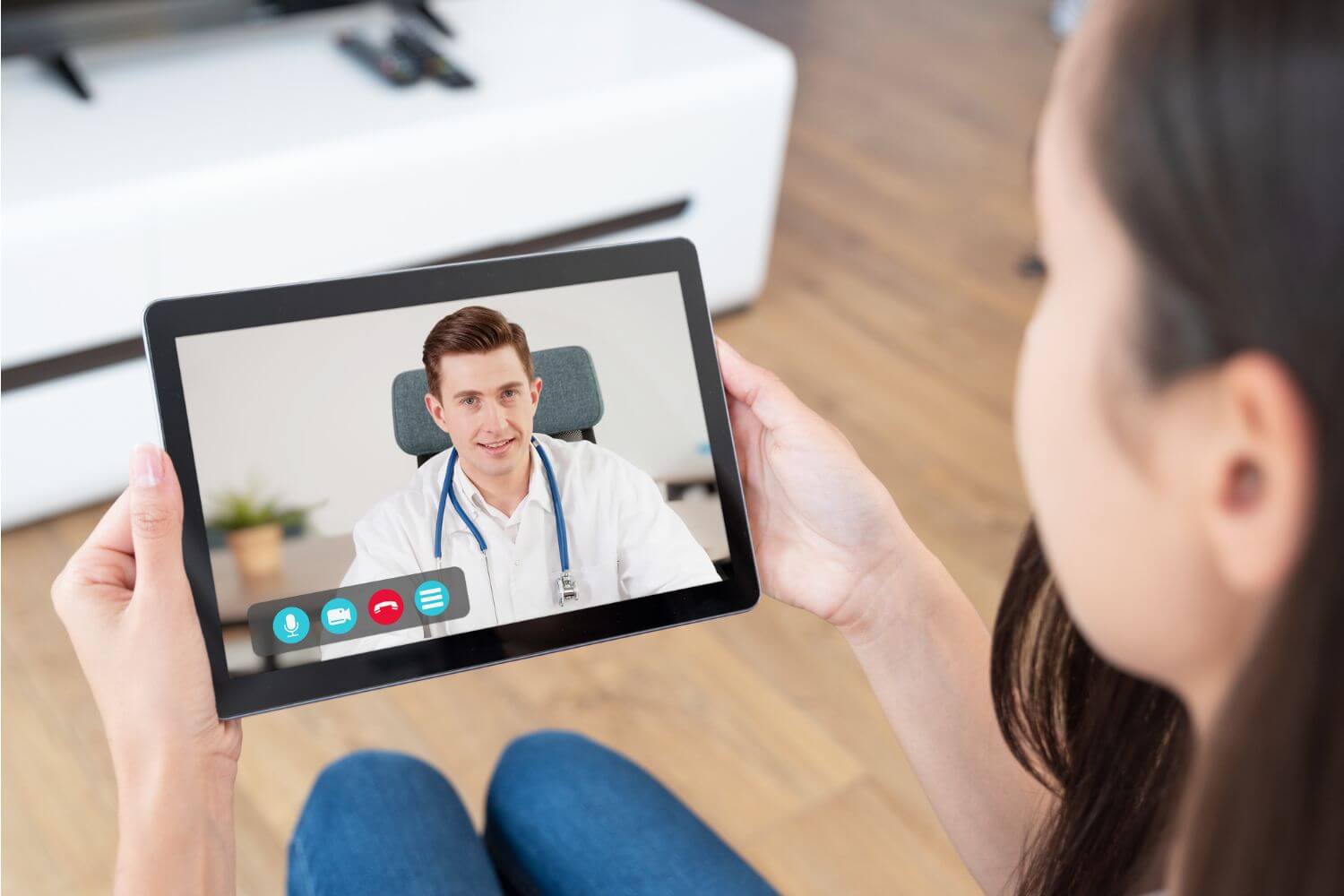 Woman holding a tablet while on a telehealth call with a doctor