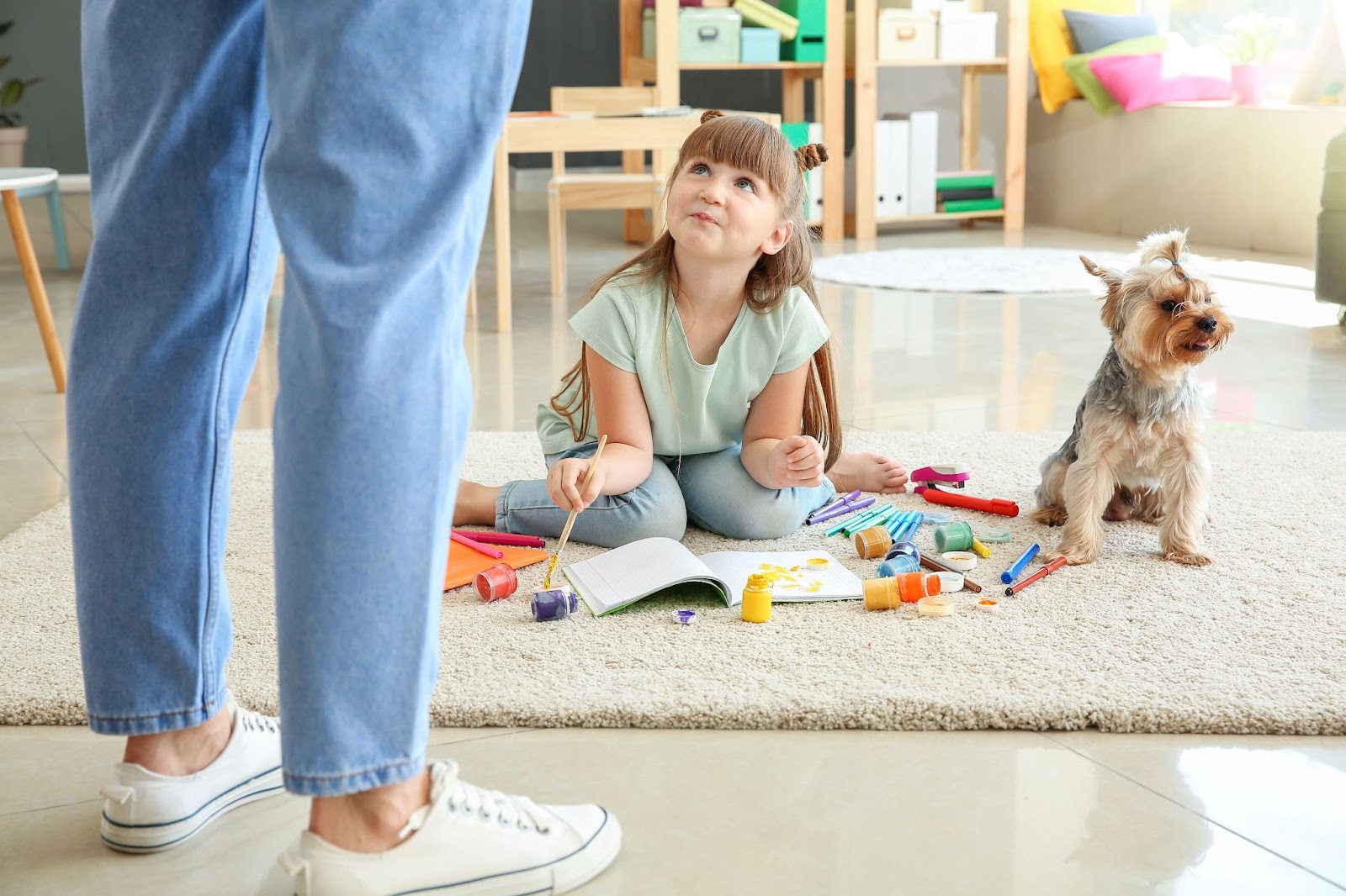 Mother looking at child who has spilled paint on white carpet - wondering how to remove paint stains from carpet