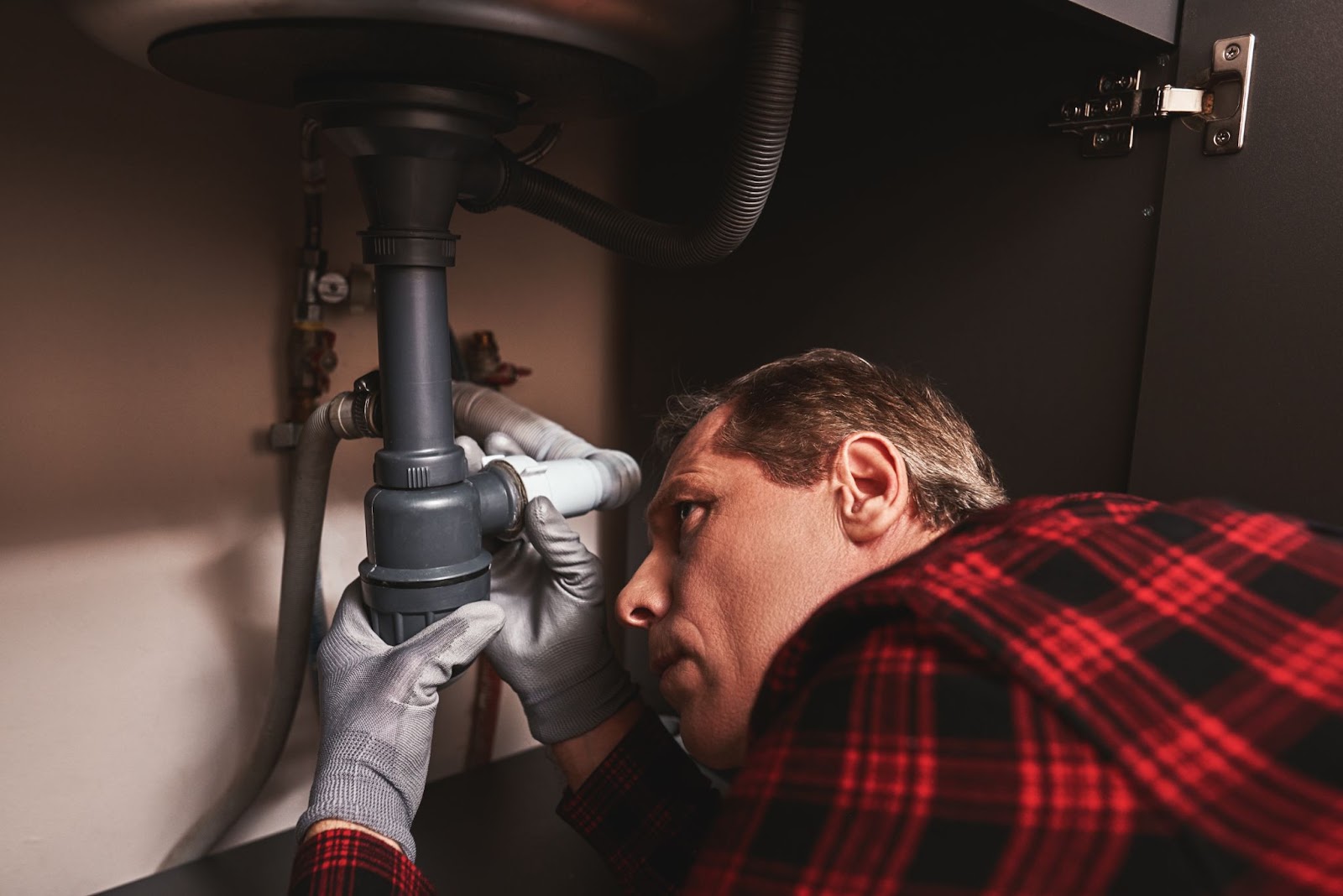 Plumber repairing pipes in a home. 