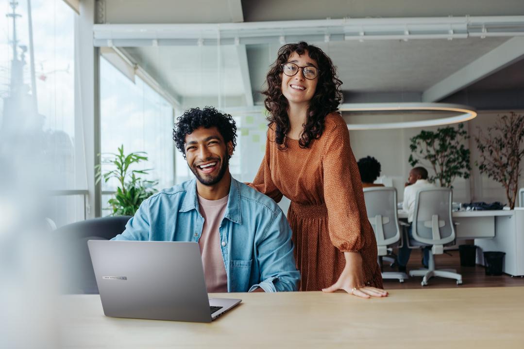  Duas pessoas com um notebook com IA em ambiente de trabalho, destacando tecnologia avançada e inovação.