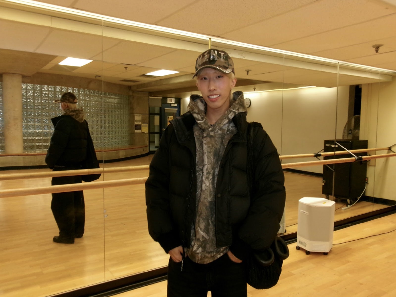 A man smiling at the camera in a dance studio