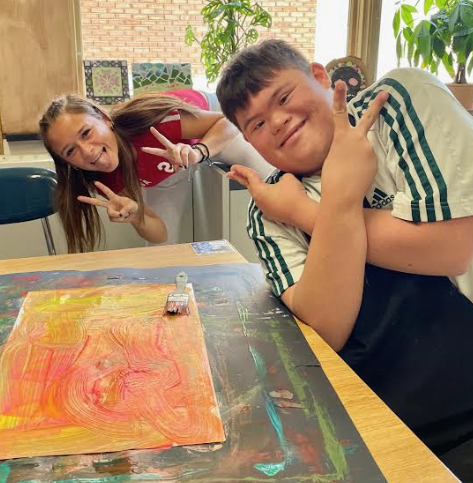 image of two students posing with their fingers in a peace sign