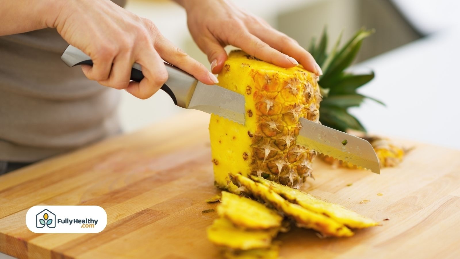 Person slicing fresh pineapple on wooden cutting board