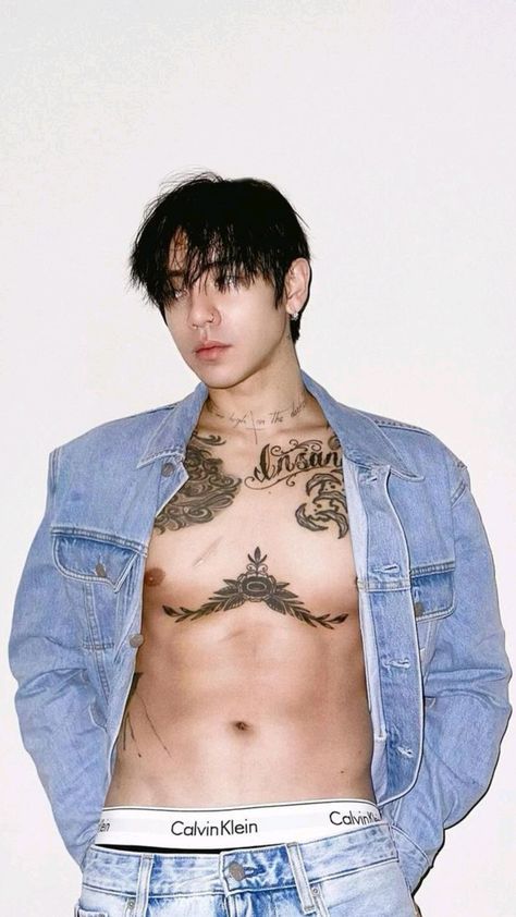 This contain DPR Ian  shirtless with tattoos on his chest standing in front of a white wall