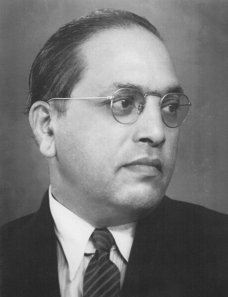 Black-and-white image of B.R. Ambedkar, wearing glasses and a suit with a neutral expression and his head facing to the left.