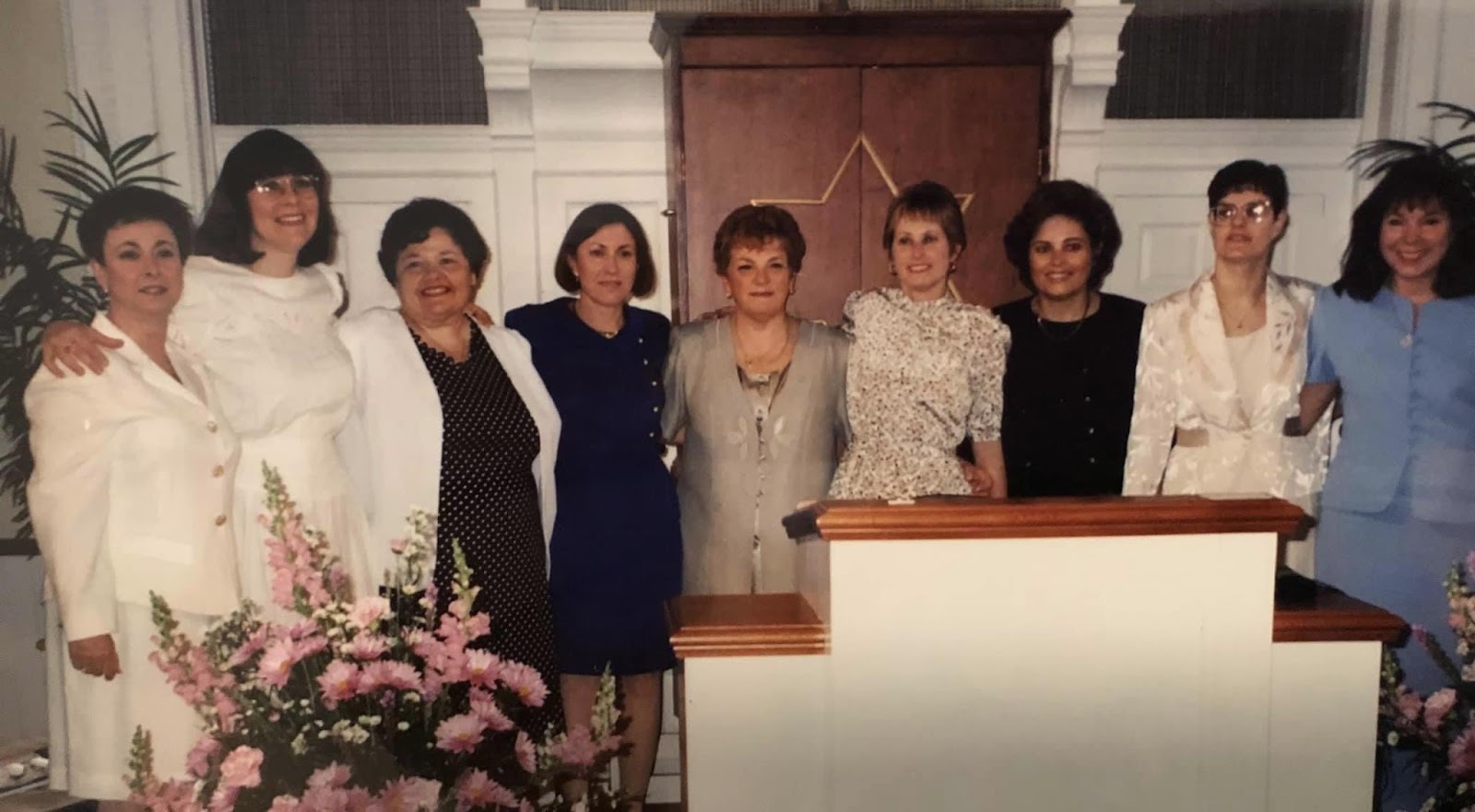 A group of women standing in front of a podium

Description automatically generated