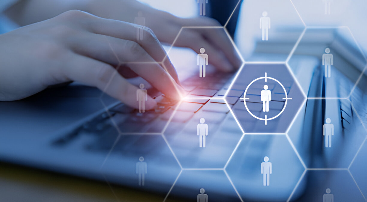Close-up of hands typing on a laptop with digital icons of people, symbolizing a personalized approach in financial services.
