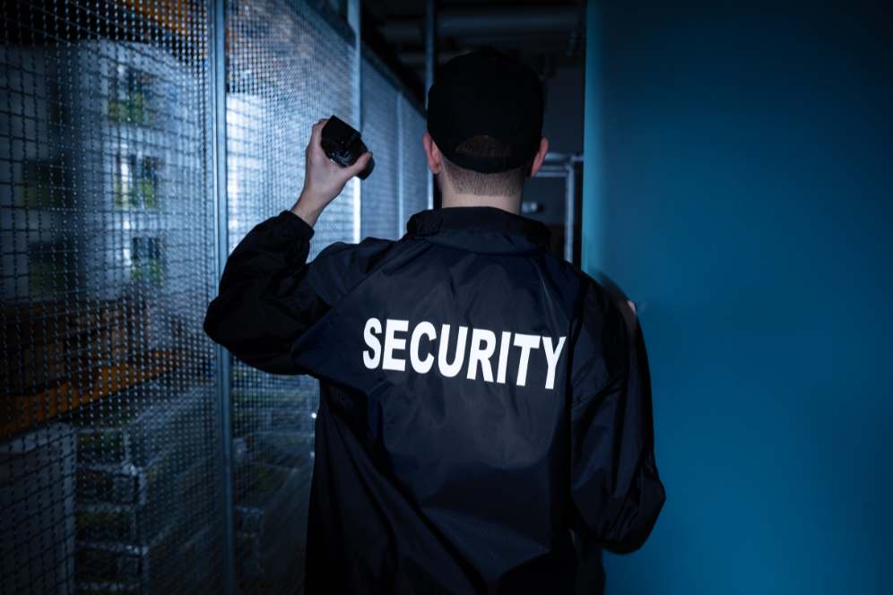 Security guard monitoring a secure facility with walkie-talkie