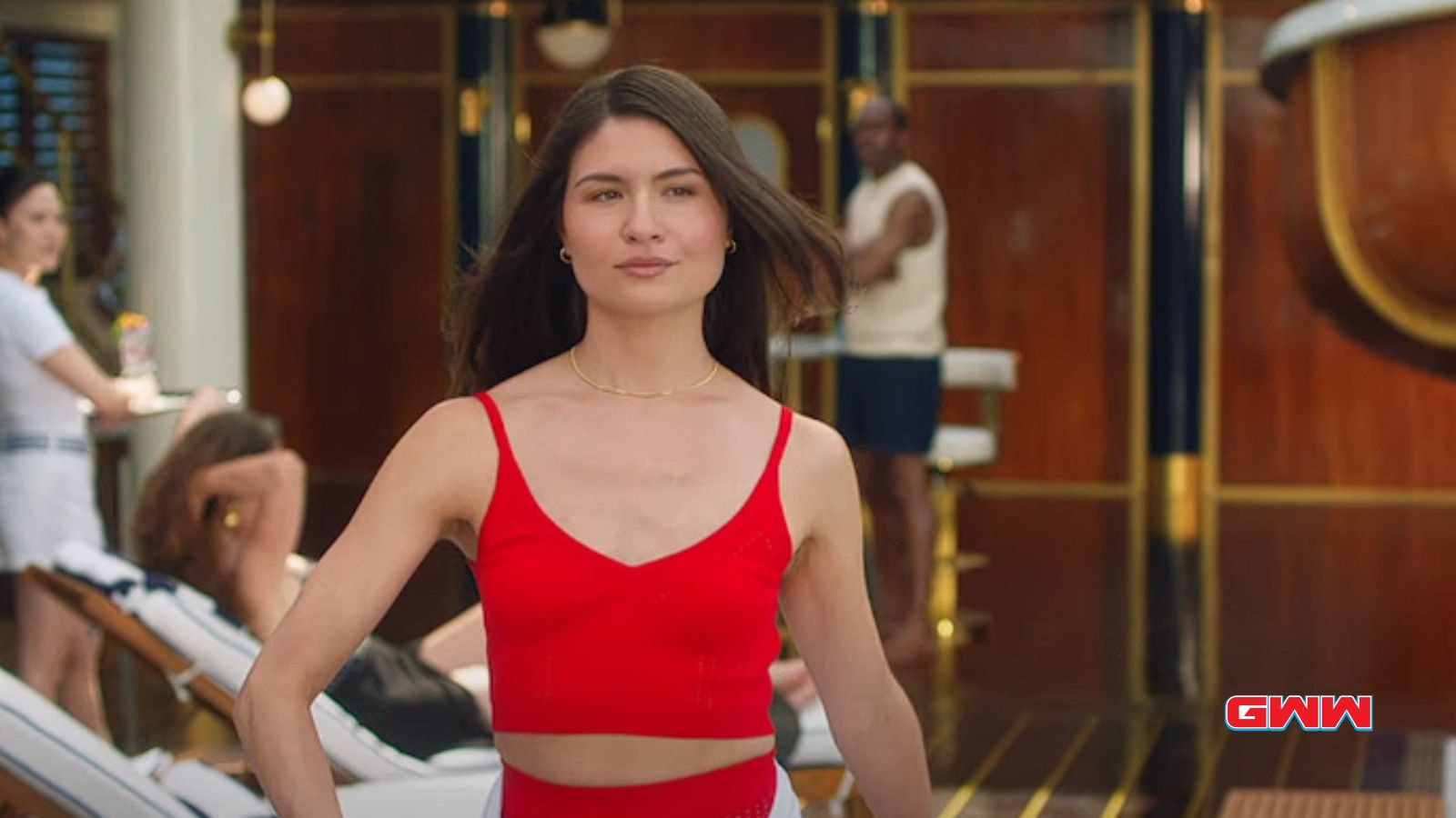 Phillipa Soo walking confidently on the cruise ship deck, stylish in red