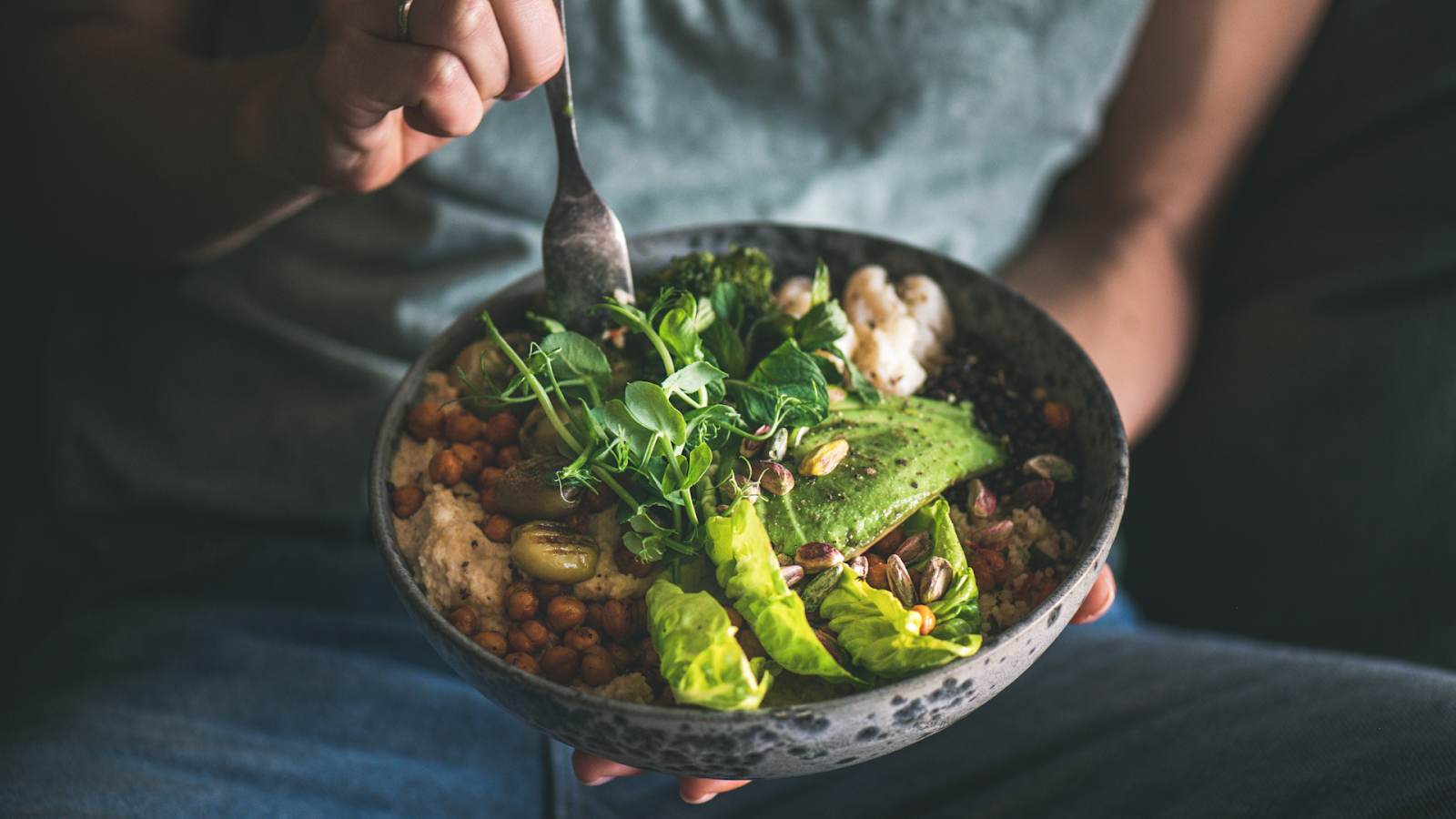 Person holding a dark speckled bowl hat has been, lettuce and other green // Healthier Veterans Today