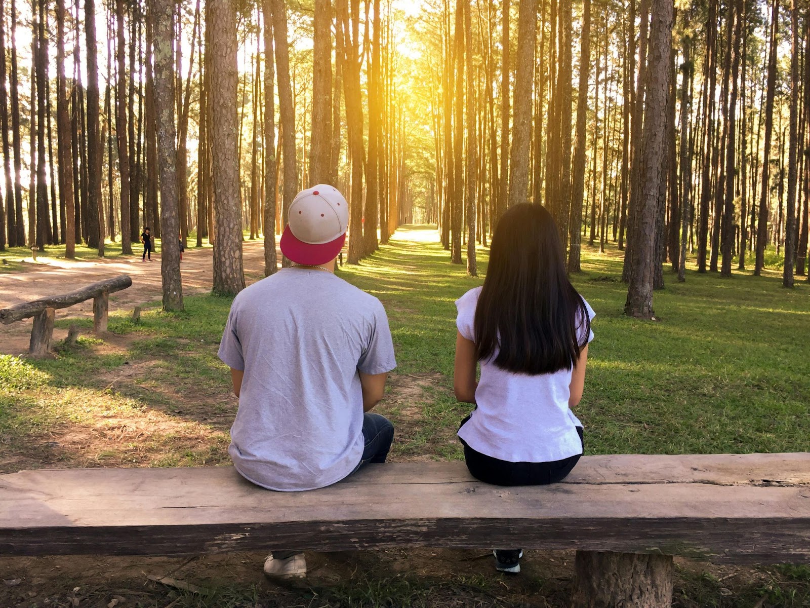 A couple sitting on a bench in the woods