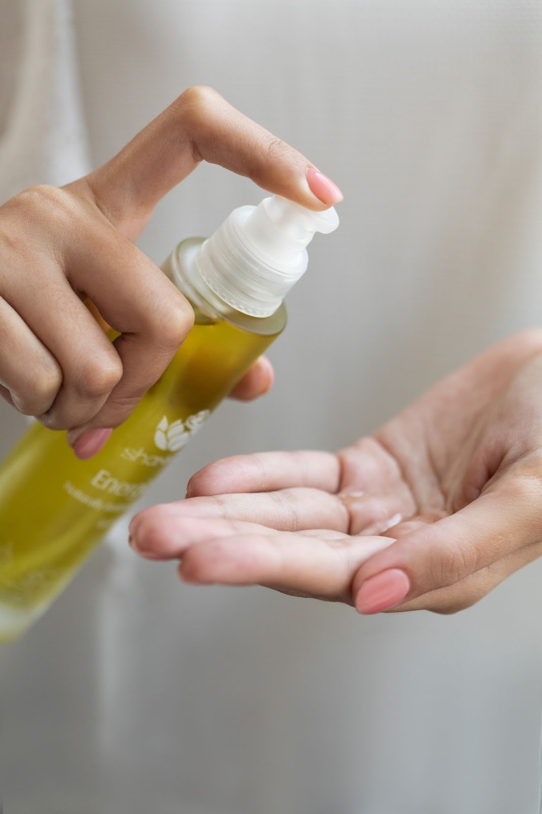 Woman applying a Shankara Naturals body oil in her hands. Featured in the blog Luscious Locks: How Body Oil Can Transform Your Hair Care Routine